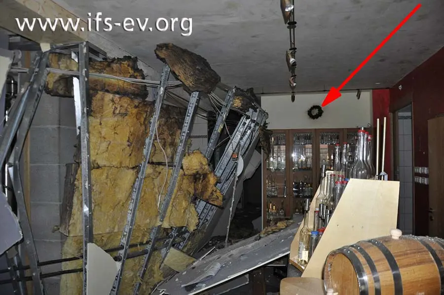 Die Trockenbauwände der Brennerei wurden in die Probierstube gedrückt. Dort gibt es oberflächliche Brandspuren, z. B. an einem Gesteck an der Wand (Pfeil).