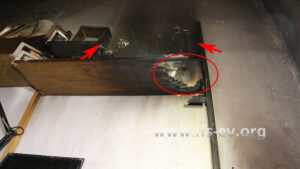 Am unteren Regalbrett gibt es eine Durchbrennung (Ellipse); das obere Regalbrett ist zwischen den Pfeilen komplett verbrannt.