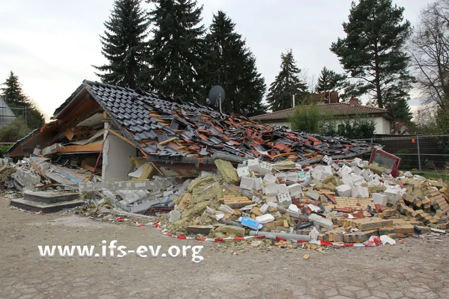 Das Haus ist zusammengesackt; nur das Dach ist als solches noch zu erkennen.