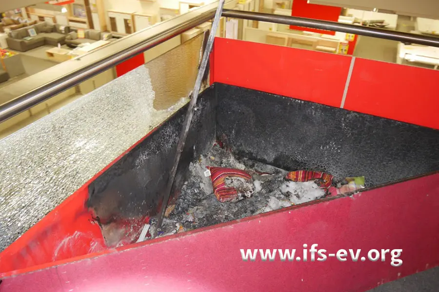 Im Brandschutt in der Kiste sind noch Kissen zu erkennen.
