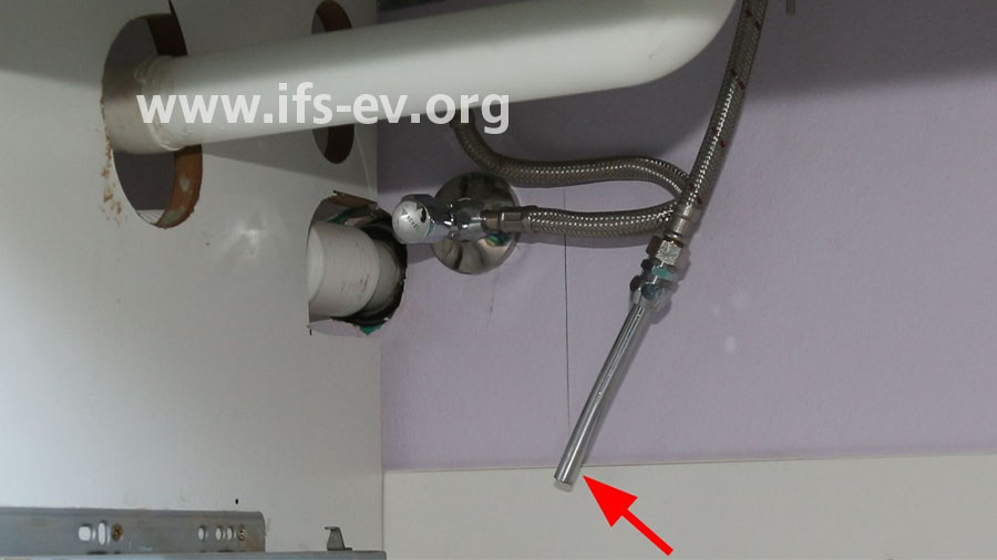 Blick unter den Waschtisch: Das Verlängerungsröhrchen (Pfeil) ist vollständig von der Klemmringverbindung getrennt.
