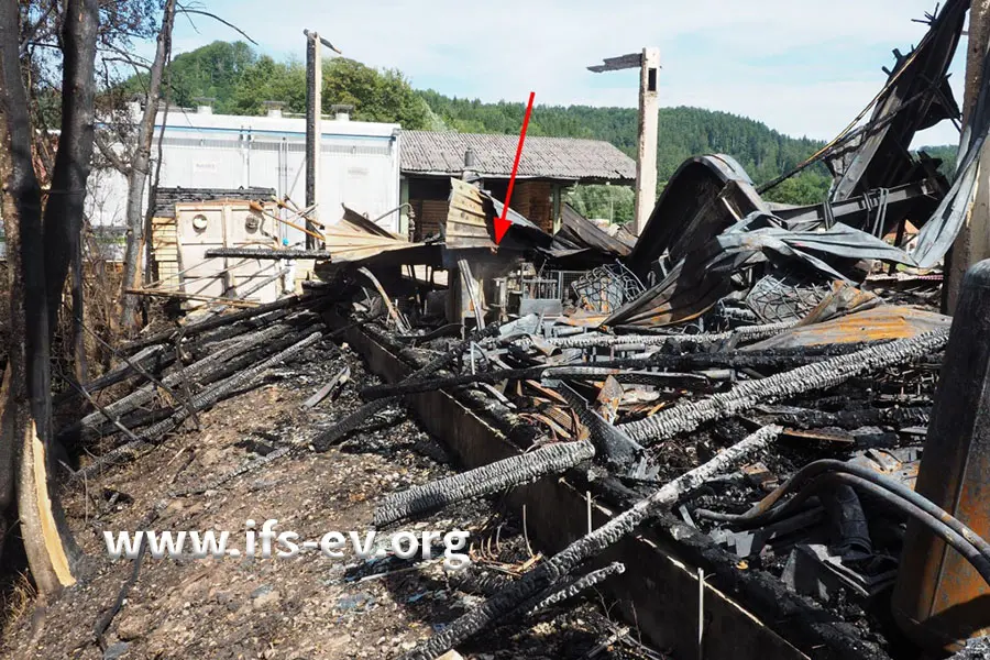Die Halle ist niedergebrannt. Der Pfeil markiert die Stelle, an der die Maschine steht.