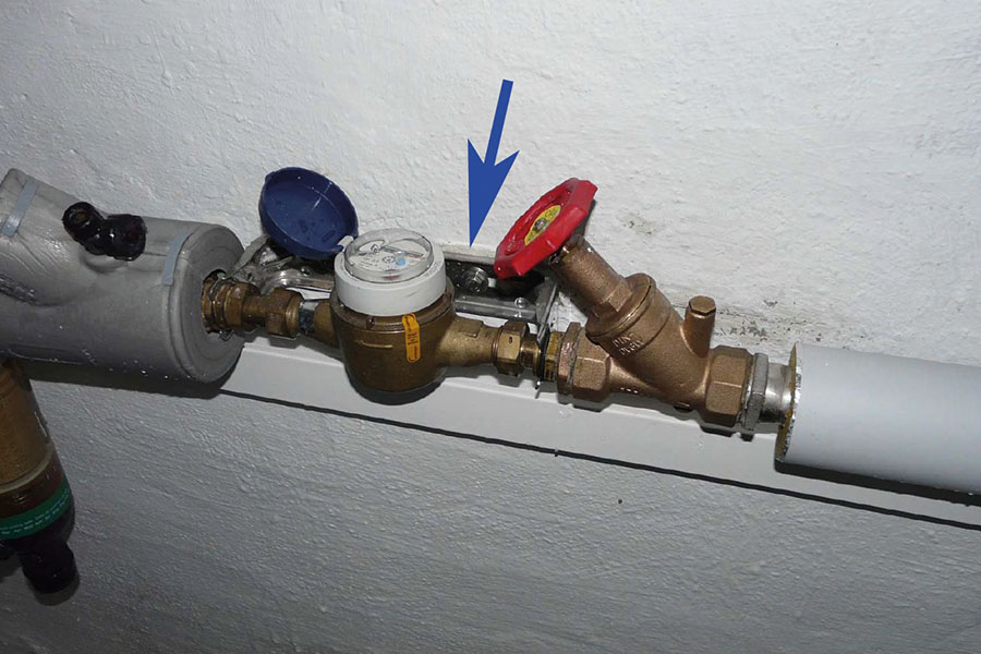 Die Einbausituation: Der Wasserzähler ist in der Anschlussgarnitur (Pfeil) fixiert.