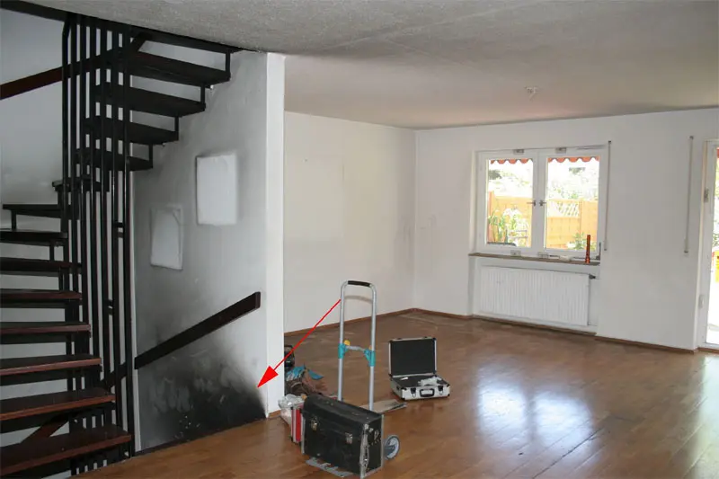 Ruß und Rauchgasablagerungen am Treppenabgang zum Keller