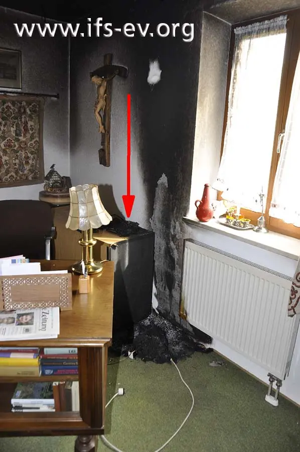 Der Brandbereich im Arbeitszimmer: Der Pfeil deutet auf die Telefonanlage.