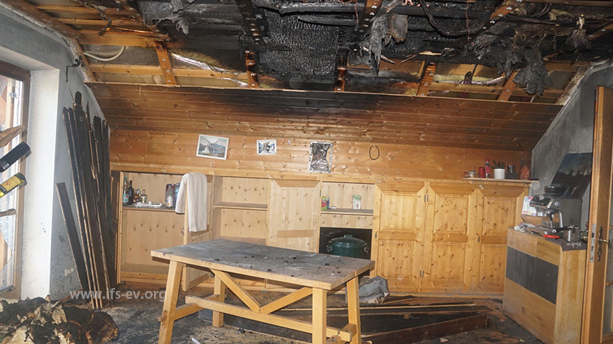 Über dem Tisch haben die Flammen auf die Zimmerdecke und den Dachstuhl übergegriffen.