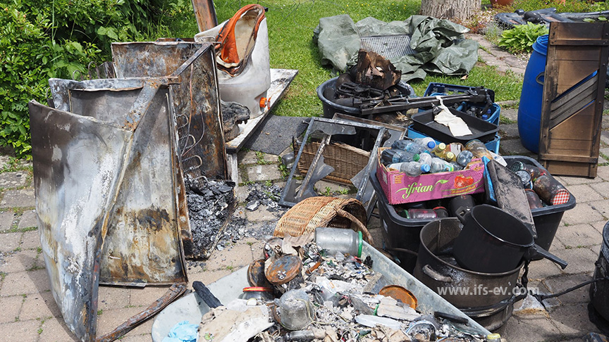 Der verbrannte Kühlschrank und andere Gegenstände aus dem Keller wurden bei den Löscharbeiten in der Garten gebracht.